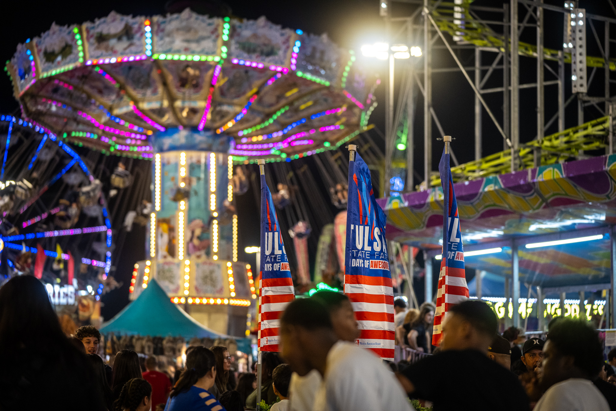 Photo of the 2026 Tulsa State Midway showing a crowd and rides